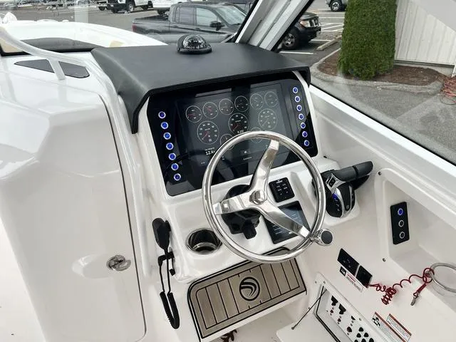 Slide: The Image of 2022 Edgewater 262CX boat dashboard with steering wheel and digital display. - 13