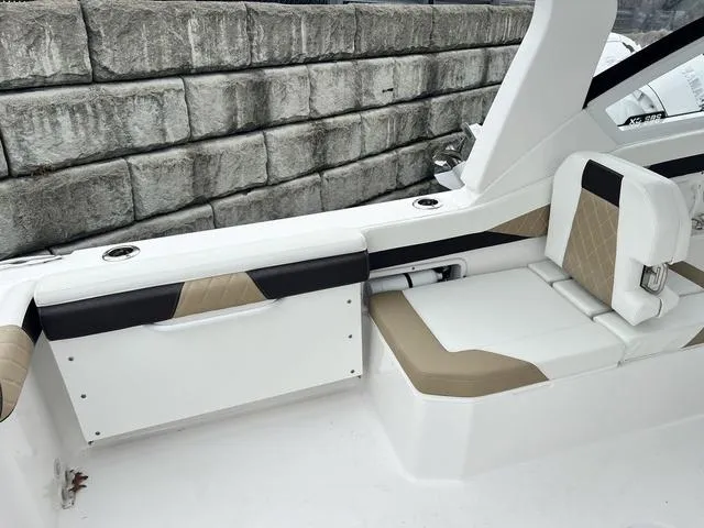 Slide: The Image of 2022 Edgewater 262CX boat interior with beige and white seating near stone wall. - 5