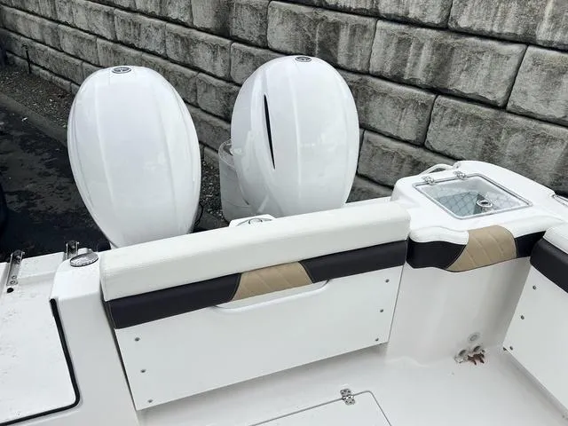 Slide: The Image of 2022 Edgewater 262CX boat with dual outboard engines and seating, docked by a stone wall. - 6