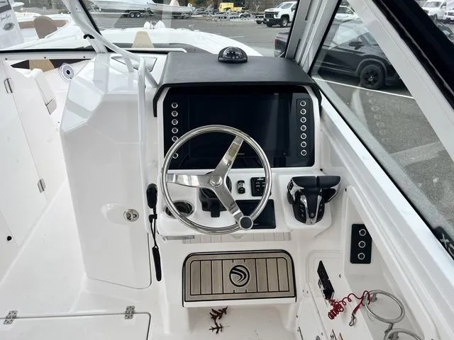 Slide: The Image of 2022 Edgewater 262CX boat cockpit with steering wheel and control panel. - 8