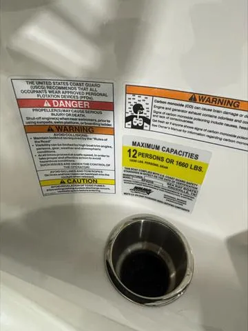 Slide: The Image of Warning labels and capacity information on a 2024 Sea Ray 210 SPX boat. - 10
