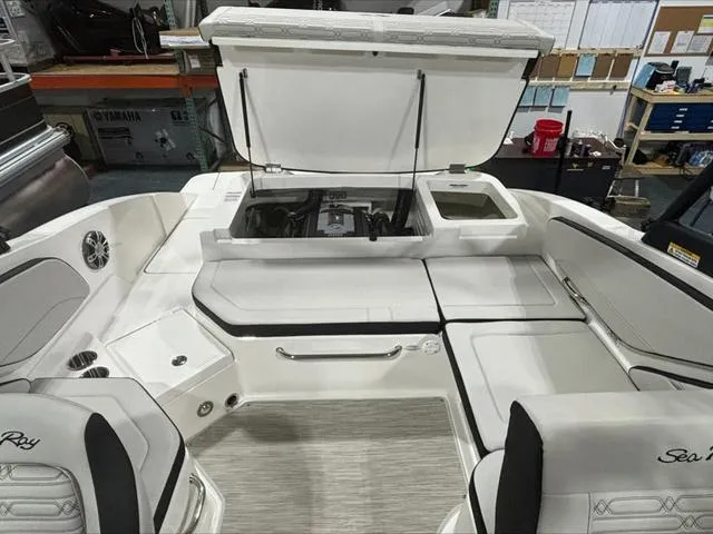 Slide: The Image of 2024 Sea Ray 210 SPX boat interior with open engine compartment, showcasing seating and storage. - 5