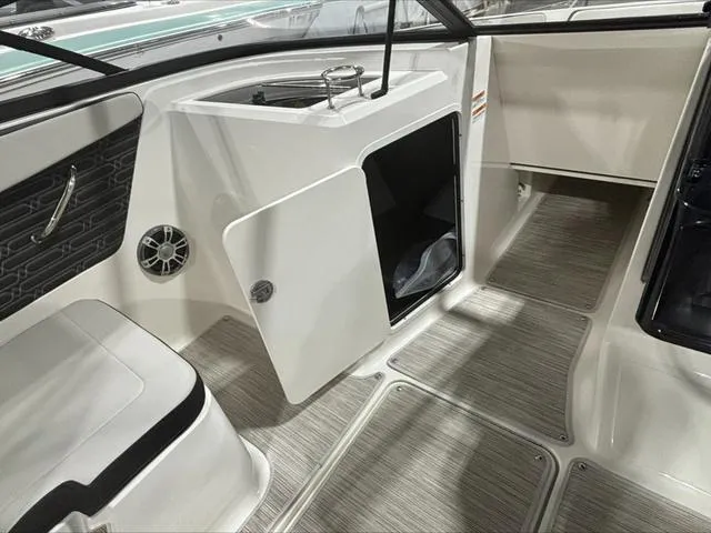 Slide: The Image of 2024 Sea Ray 210 SPX boat interior with open storage compartment and seating. - 7