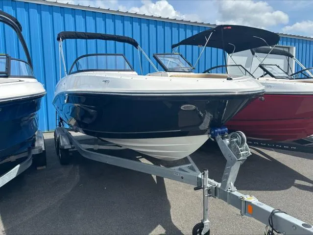 Slide: The Image of 2024 Bayliner VR6 boat on trailer, parked outdoors near blue building. - 1
