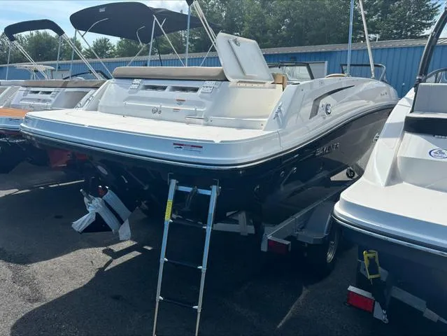 Slide: The Image of 2024 Bayliner VR6 boat with ladder, parked on trailer, in a marina setting. - 4