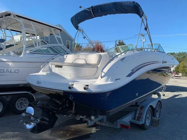 Slide: The Image of 2006 Hurricane 25' DC boat on trailer, blue and white design, parked outdoors. - 10
