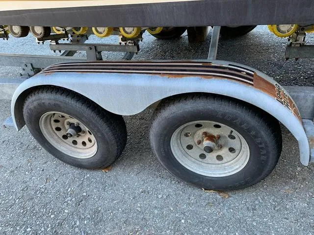 Slide: The Image of Trailer wheels for 2006 Hurricane 25' DC boat on gravel surface. - 12