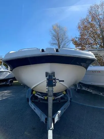 Slide: The Image of 2006 Hurricane 25' DC boat on trailer, parked outdoors under clear blue sky. - 4