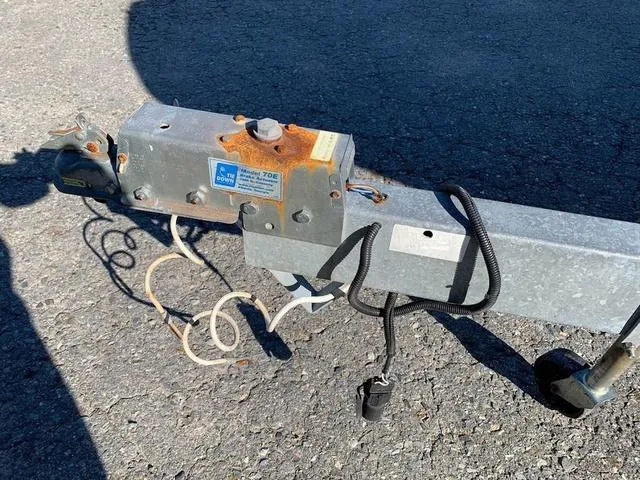 Slide: The Image of Rusty trailer hitch of a 2006 Hurricane 25' DC boat on asphalt. - 6