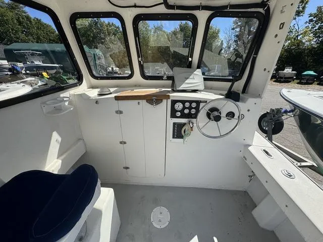 Slide: The Image of Interior of a 1996 Eastern 27 Lobster Fisherman boat, featuring steering wheel and controls. - 6