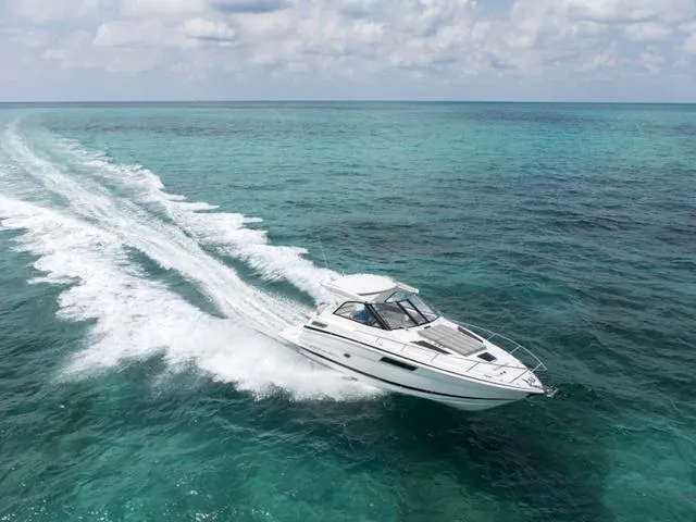 Slide: The Image of 2017 Regal 35 Sport Coupe cruising on turquoise ocean waters. - 1