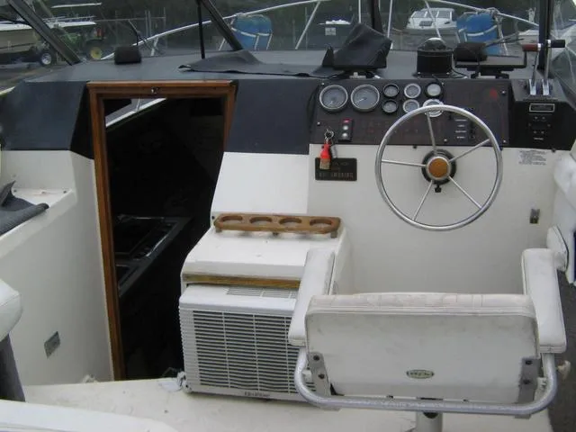 Slide: The Image of 1983 Bayliner 2850 Contessa boat cockpit with steering wheel and control panel. - 13