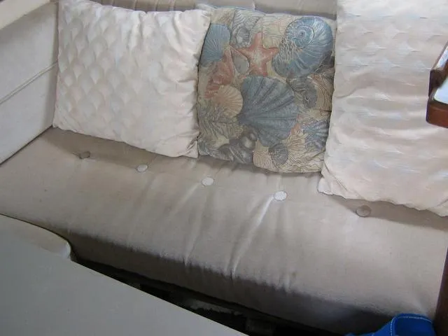 Slide: The Image of 1983 Bayliner 2850 Contessa interior with beige seating and decorative pillows. - 7