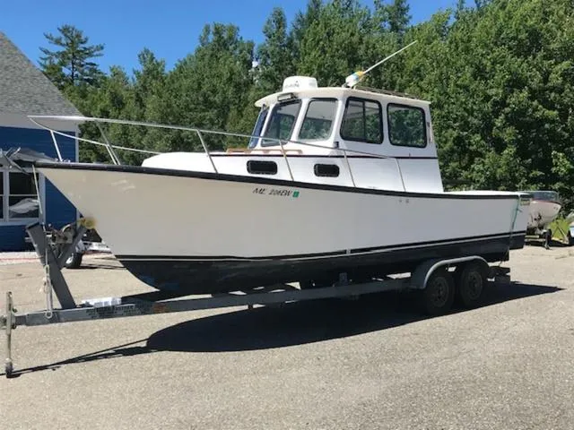 Slide: The Image of 2003 Eastern 27' Lobster boat on trailer, parked outdoors, surrounded by trees. - 6