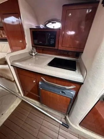 Slide: The Image of 2007 Sea Ray 280 Sundancer cabin kitchen with microwave, sink, and stove. - 10