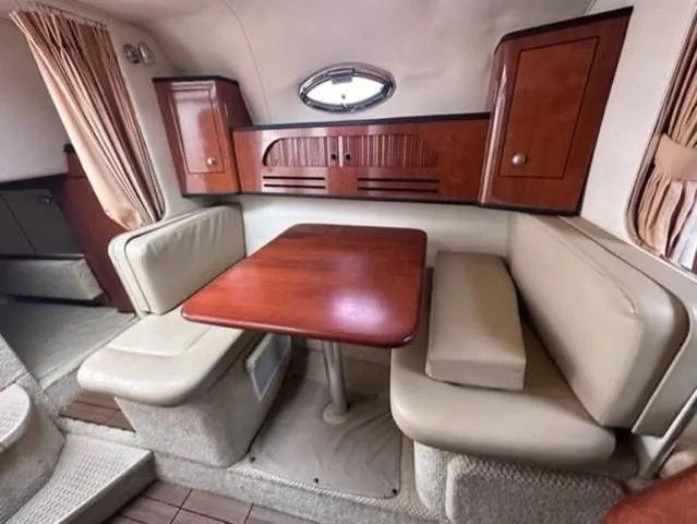 Slide: The Image of Interior of 2007 Sea Ray 280 Sundancer with wooden table and cushioned seating. - 11