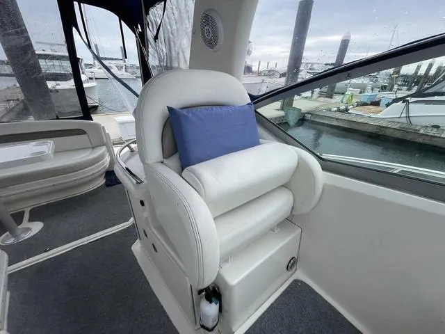 Slide: The Image of Captain's seat on 2003 Sea Ray 340 Sundancer yacht with blue cushion, docked at marina. - 13