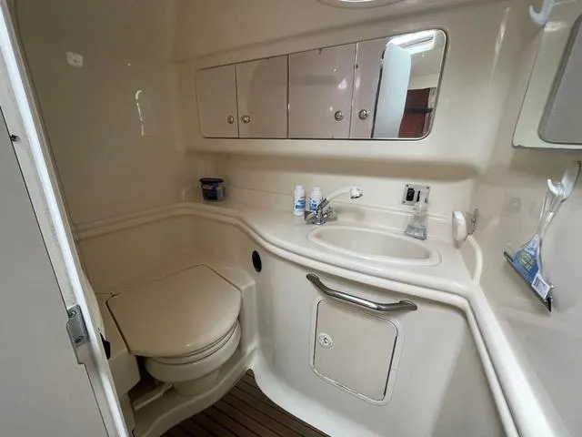Slide: The Image of 2003 Sea Ray 340 Sundancer bathroom with sink, toilet, and storage cabinets. - 9