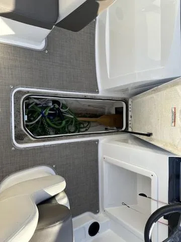 Slide: The Image of 2018 Bayliner VR4 boat interior storage compartment with coiled rope and paddle. - 11