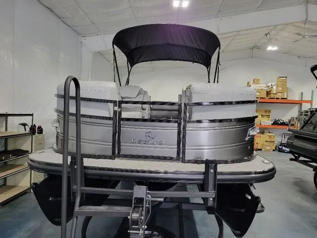 Slide: The Image of 2024 Regency 250 DL3 pontoon boat in showroom, featuring sleek design and canopy. - 6