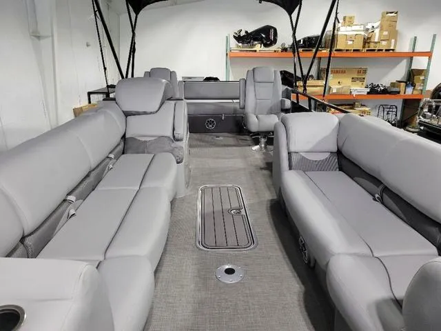 Slide: The Image of 2024 Regency 250 DL3 pontoon boat interior with gray seating and spacious layout. - 7