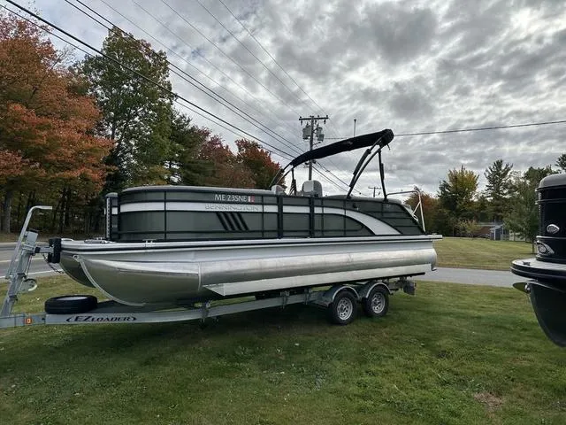Slide: The Image of 2021 Bennington 22 LFB pontoon boat on trailer, parked on grass under cloudy sky. - 1
