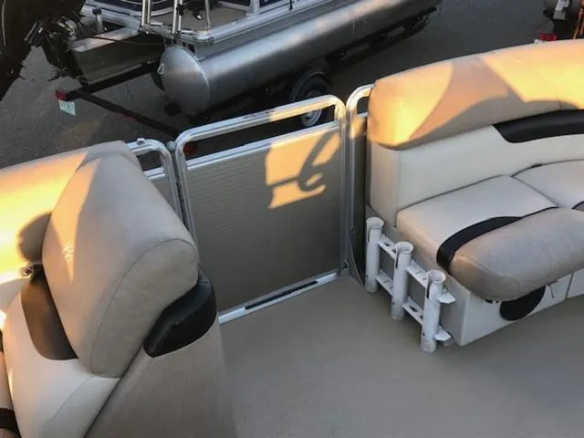 Slide: The Image of 2013 Cypress Cay Seabreeze 180 pontoon boat interior with beige seating and metal railing. - 14
