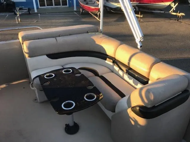 Slide: The Image of 2013 Cypress Cay Seabreeze 180 pontoon boat interior with cushioned seating and table. - 15