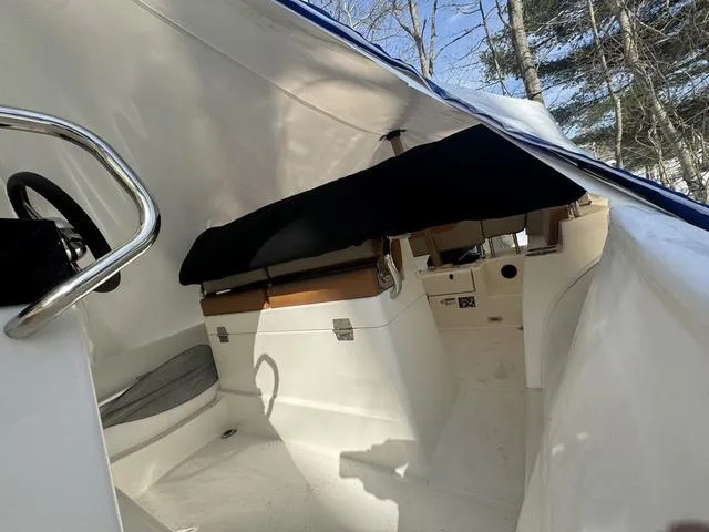 Slide: The Image of 2024 Zodiac Boats Medline 6.8 interior, featuring seating and steering wheel under canopy. - 4