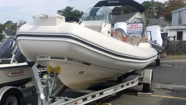 Slide: The Image of 2024 Zodiac Boats Medline 6.8 on trailer, for sale sign visible in background. - 7