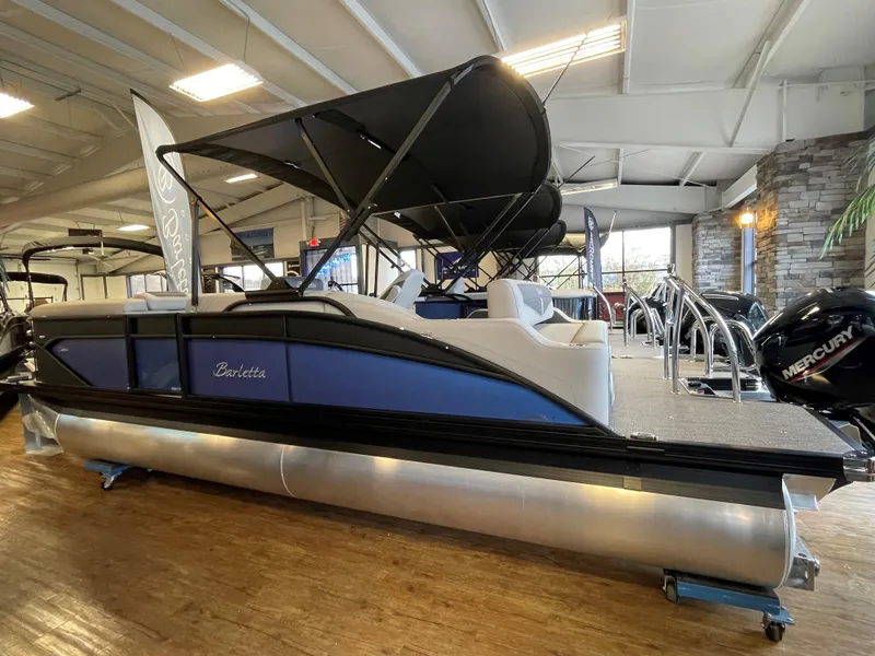 Slide: The Image of 2025 Barletta Cabrio 22U pontoon boat displayed indoors with sleek design and modern features. - 1