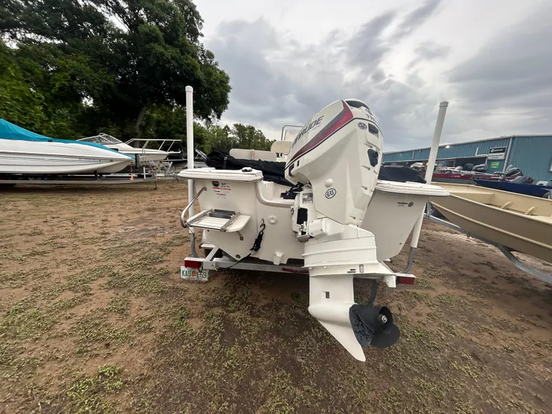 Slide: The Image of 2018 Carolina Skiff 198 DLV boat with outboard motor, parked on grass. - 8
