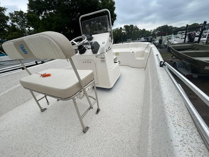 Slide: The Image of 2018 Carolina Skiff 198 DLV boat with console and seating, parked outdoors. - 9
