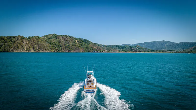 Slide: The Image of 2024 Maverick Yachts Costa Rica 36 Walkaround cruising on blue ocean with lush green hills. - 6