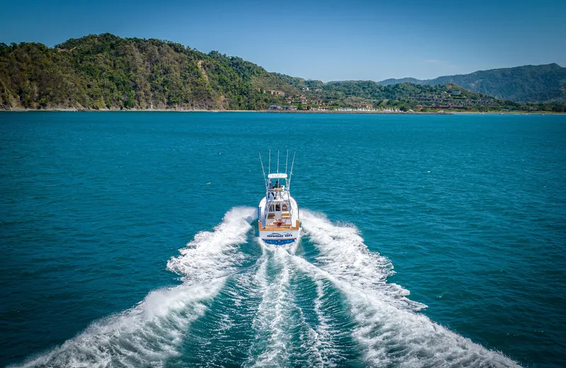 Slide: The Image of 2024 Maverick Yachts Costa Rica 36 Walkaround cruising in turquoise waters near lush coastline. - 7