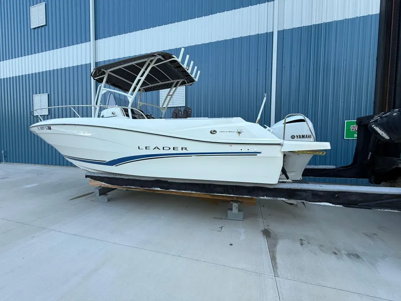 The Image of 2021 Jeanneau Leader 7.5 CC boat with Yamaha engine, docked near a blue building. - 0
