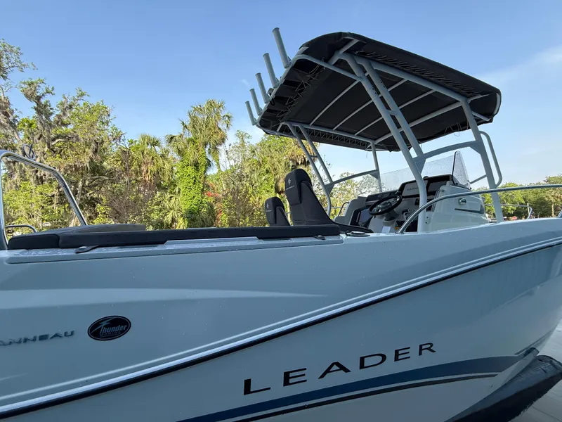 Slide: The Image of 2021 Jeanneau Leader 7.5 CC boat with canopy, docked near lush greenery. - 16