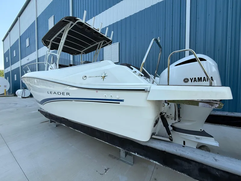 Slide: The Image of 2021 Jeanneau Leader 7.5 CC boat with Yamaha engine, docked near a blue building. - 18