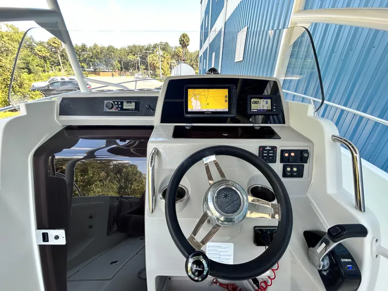 Slide: The Image of 2021 Jeanneau Leader 7.5 CC boat dashboard with steering wheel and navigation display. - 33