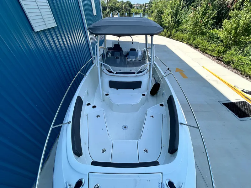 Slide: The Image of 2021 Jeanneau Leader 7.5 CC boat with canopy, docked beside a blue building. - 41