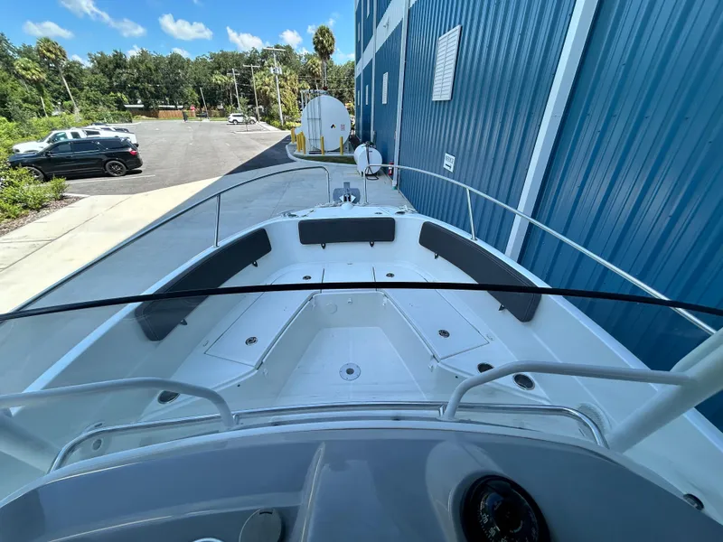 Slide: The Image of 2021 Jeanneau Leader 7.5 CC boat docked near blue building, outdoor view. - 43