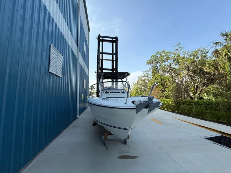 Slide: The Image of 2021 Jeanneau Leader 7.5 CC boat beside blue building, outdoor setting. - 9