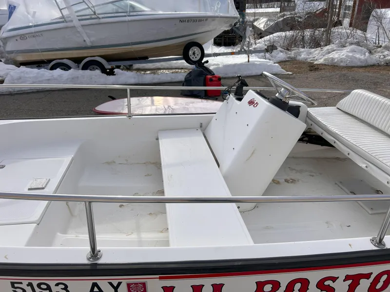 Slide: The Image of 1998 Boston Whaler 13 Sport boat interior with white seating and steering console. - 11