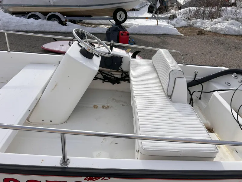 Slide: The Image of 1998 Boston Whaler 13 Sport boat interior with white seating and steering console. - 12