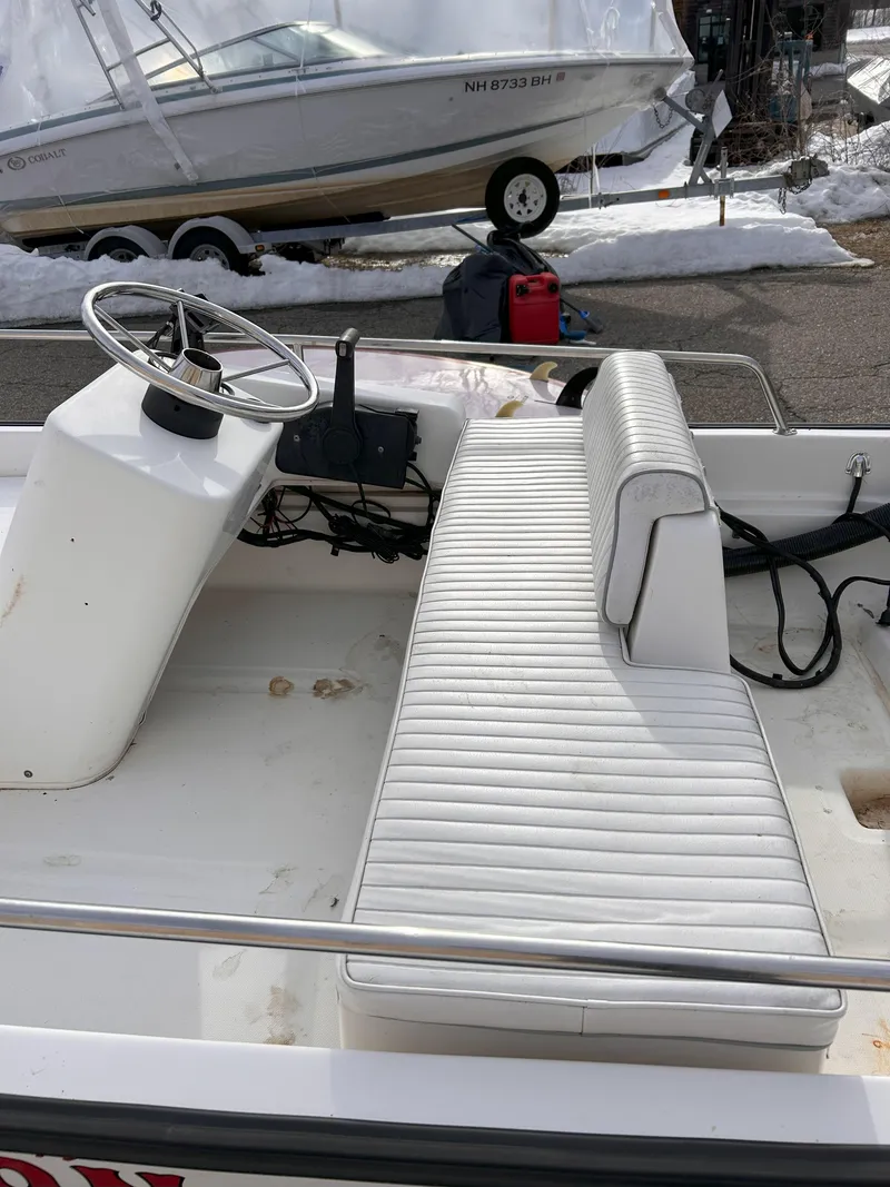 Slide: The Image of 1998 Boston Whaler 13 Sport boat interior with white seating and steering wheel. - 13