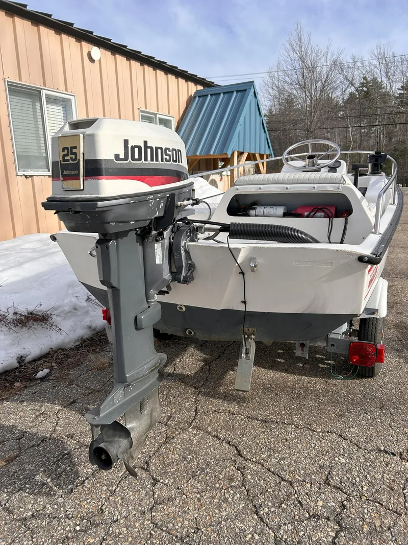 Slide: The Image of 1998 Boston Whaler 13 Sport boat with Johnson 25 outboard motor, parked outdoors. - 25