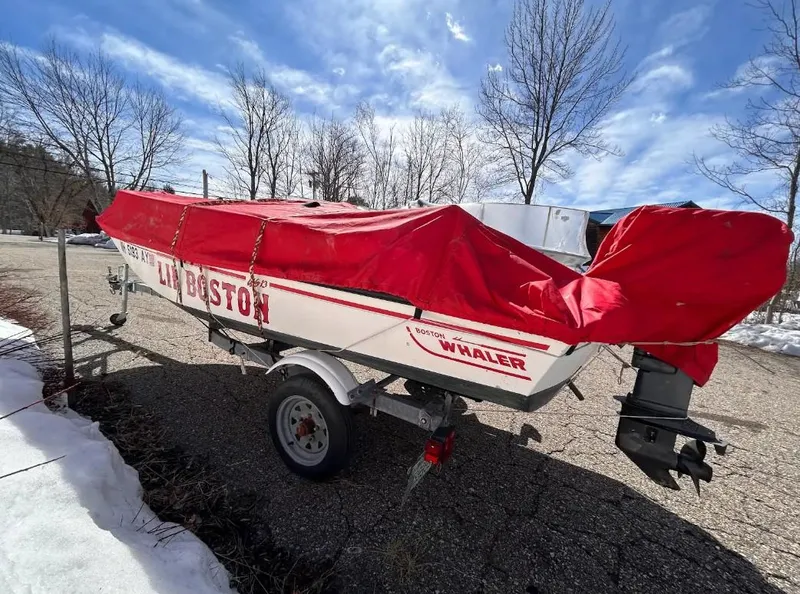Slide: The Image of 1998 Boston Whaler 13 Sport boat with red cover on trailer, parked outdoors. - 3