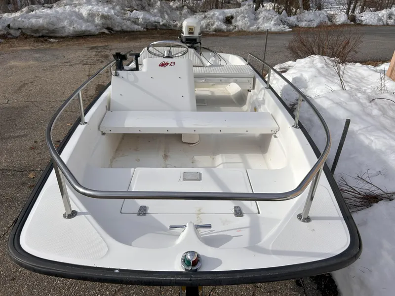 Slide: The Image of 1998 Boston Whaler 13 Sport boat on snowy driveway, showcasing sleek design and sturdy railings. - 5