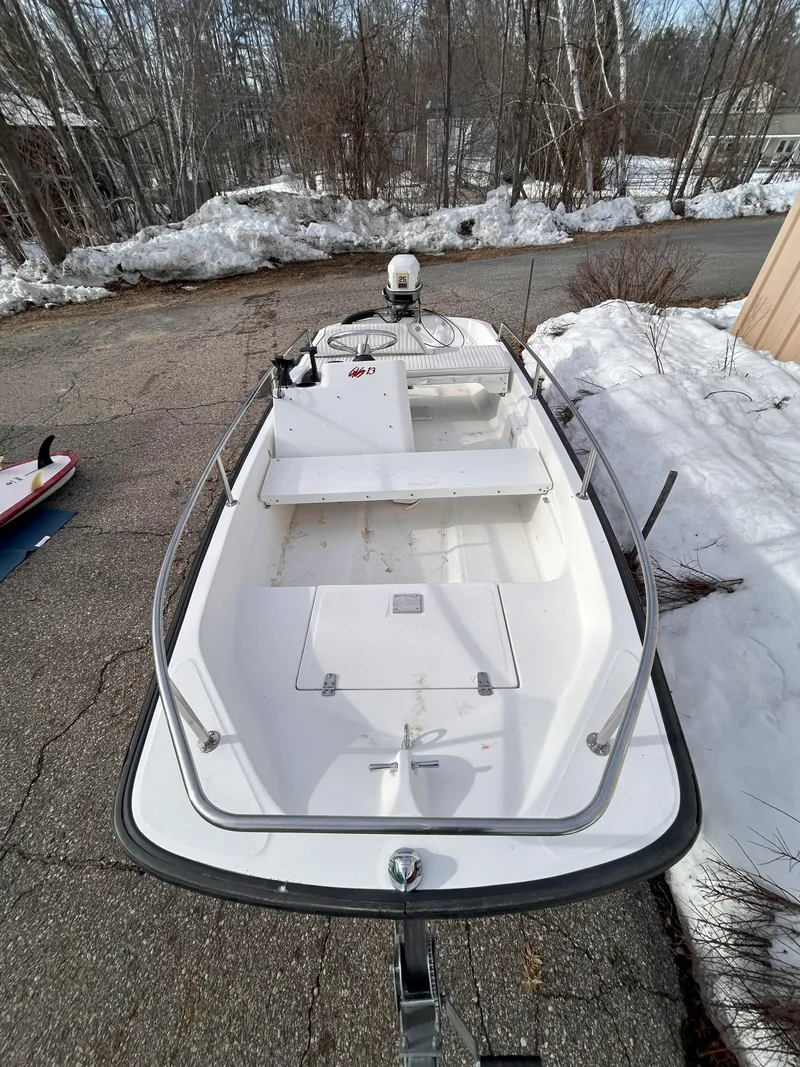 Slide: The Image of 1998 Boston Whaler 13 Sport boat on snowy driveway, showcasing sleek design and winter setting. - 6