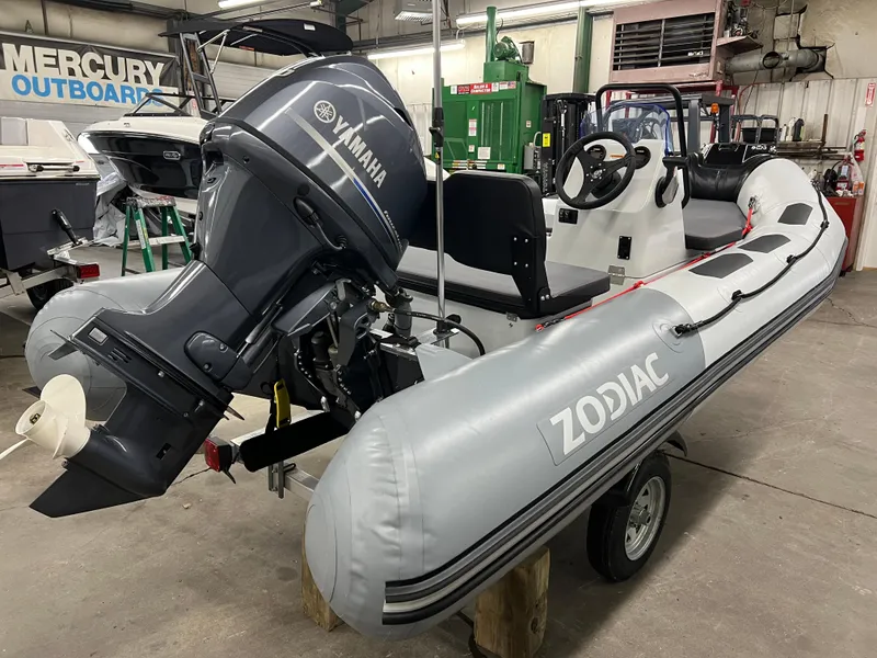 Slide: The Image of 2023 Zodiac Open 4.2 inflatable boat with Yamaha outboard motor in a workshop setting. - 2